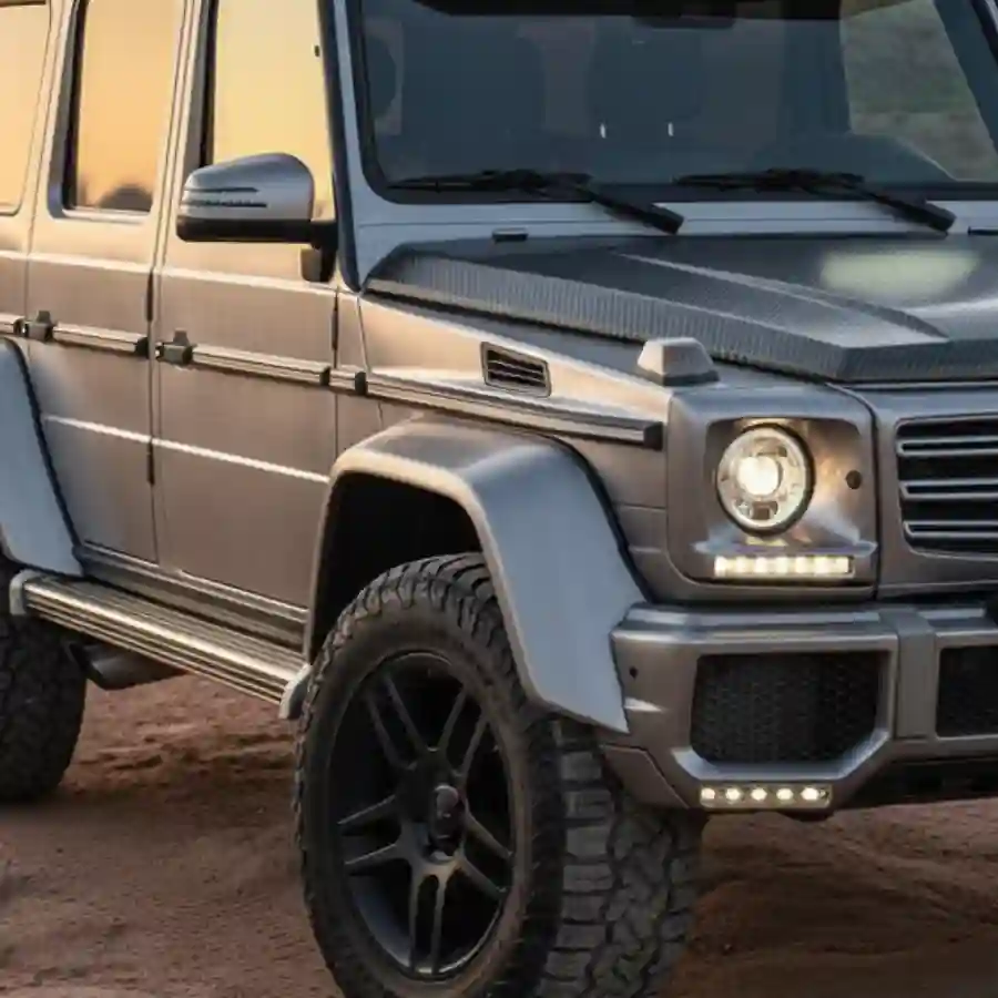 Mercedes G-Wagon G550 luxury vehicle with a sleek silver exterior, carbon fiber accents, and rugged black wheels, showcasing customization options for limousine configurations.