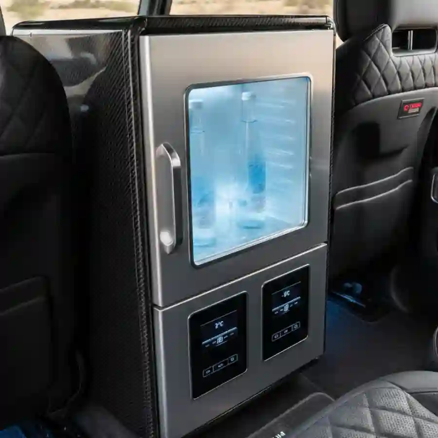 Luxury interior fridge console in a Mercedes G-Wagon G63 limousine, featuring illuminated storage for beverages and digital temperature controls, emphasizing customization options for high-end vehicle interiors.