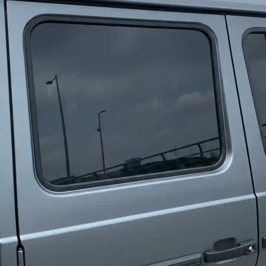 Mercedes G-Wagon G550 limousine side window with ballistic tint, reflecting urban environment and enhancing luxury vehicle customization options.