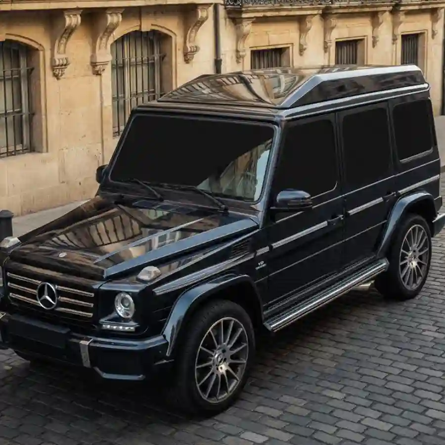 Mercedes G-Wagon G550 limousine in black, showcasing luxury design and raised roof, set against a cobblestone street.